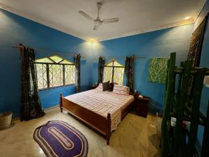 1 dormitorio con 1 cama con paredes y ventanas azules en Mama's House, en Kibweni