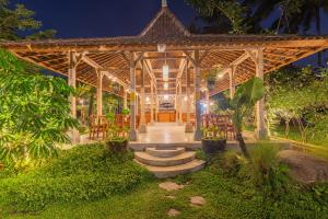 einem Holzpavillon mit Tischen und Stühlen im Garten in der Unterkunft Abian Ubud View in Ubud