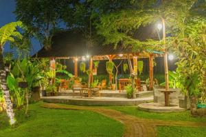 eine Terrasse mit Tischen und Stühlen in der Nacht in der Unterkunft Abian Ubud View in Ubud
