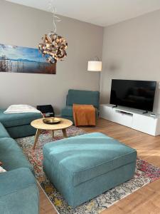 a living room with a couch and a tv at Ferienhaus Baron mit eigener Sauna in Marquartstein