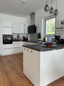 a kitchen with white cabinets and a black counter top at Ferienhaus Baron mit eigener Sauna in Marquartstein