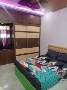 1 dormitorio con 1 cama con un edredón colorido en RRRHomestay en Tirupati