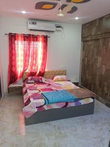 Schlafzimmer mit einem Bett und roten Vorhängen in der Unterkunft RRRHomestay in Tirupati