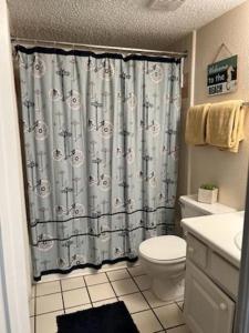 ein Bad mit einem Duschvorhang und einem WC in der Unterkunft 1BR Comfort Villa Near Old Town, Disney Universal & Parks in Kissimmee