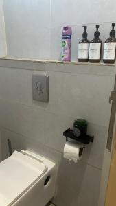 baño con aseo y estante con botellas de odorizantes en نزل الزلفي لشقق المخدومة, en Az Zulfi