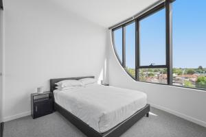 a bedroom with a bed and a large window at Generous 2-Bed Apartment with Great Amenities in Melbourne +6 photos