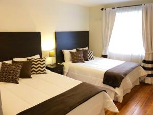 クエンカにあるNASS Bed & Breakfastのベッドルーム1室(ベッド2台、窓付)