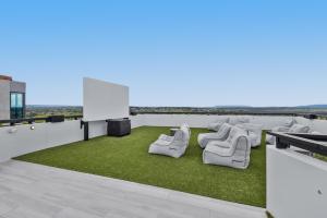 a rooftop patio with chairs and grass at Generous 2-Bed Apartment with Great Amenities in Melbourne