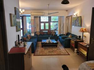 a living room with a couch and a table at Ivy's Home Stay in Bhopal +4 photos