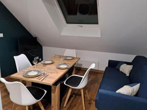 a dining room table with chairs and a blue couch at T2 / 24h du Mans / Circuit / Karting / Antares / Boulerie Jump / Stade de foot in Le Mans +20 photos