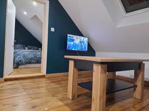 a room with a table with a tv on a wall at T2 / 24h du Mans / Circuit / Karting / Antares / Boulerie Jump / Stade de foot in Le Mans