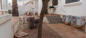 un patio con 2 condizionatori e un albero di MAISON ENTIERE AVEC PISCINE, WIFI, GRAND SOLARIUM ET TERRAIN ARBORE a Orihuela