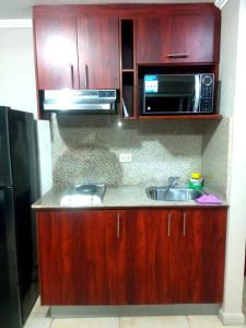 eine Küche mit einer Spüle und einer Mikrowelle in der Unterkunft Departamento vista al rio. in Guayaquil