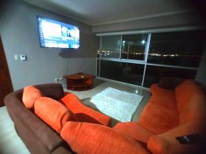 ein Wohnzimmer mit einem Sofa und einem Flachbild-TV in der Unterkunft Departamento vista al rio. in Guayaquil