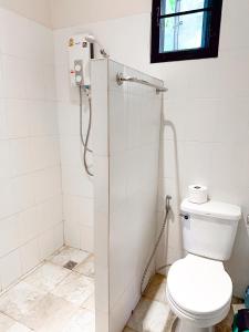 uma casa de banho branca com um WC e uma janela em Jungle Vibes em Thongsala