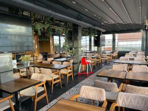an empty restaurant with tables and chairs and a large screen at Blue Pera İstanbul Hotel in Istanbul