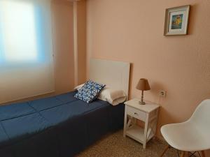 バレンシアにあるValencia Port Beachのベッドルーム(青いベッド1台、テーブル、ランプ付)