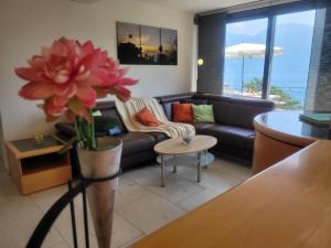 ein Wohnzimmer mit einem Sofa und einem Tisch in der Unterkunft Casa Moorea - b44923 in Brione sopra Minusio