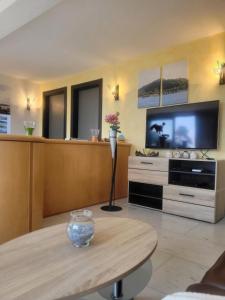 ein Wohnzimmer mit einem Tisch und einem TV in der Unterkunft Casa Moorea - b44923 in Brione sopra Minusio