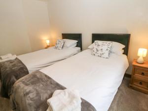 two twin beds in a room with two lamps at Cherry Tree Cottage in Ashbourne