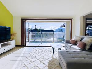 a living room with a couch and a tv at Waterfront Haven Balinese Villa at Bundall in Gold Coast