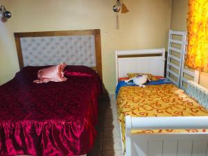 Un dormitorio con 2 camas con sábanas rojas y una falda en Las Caléndulas en Ushuaia
