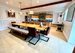 a kitchen and dining room with a wooden table and chairs at The Mill House in Santon