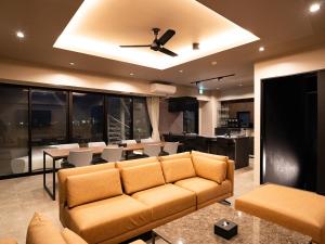 un soggiorno con un divano e un ventilatore a soffitto di ユナイテッドリゾート北谷オーシャンフロント a Chatan