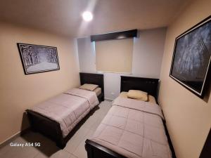 2 Betten in einem kleinen Zimmer mit einem TV in der Unterkunft Valley Views -Cozy and Matchless Views of San Jose in San Pablo