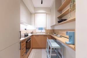 a kitchen with wooden cabinets and a counter with a stool at Urban Folks Svolou in Thessaloniki