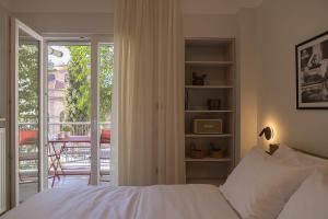 a bedroom with a bed and a balcony with a table at Urban Folks Svolou in Thessaloniki