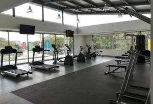 un gimnasio con cintas de correr y elípticas en una habitación con ventanas en Valley Views -Cozy and Matchless Views of San Jose, en San Pablo