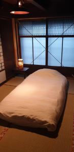 a bed in a room with a large window at Johns House じょんのやど in Himeji