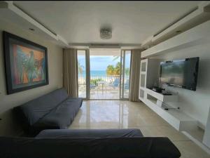 Il comprend un salon doté d'un canapé et d'une télévision à écran plat. dans l'établissement Marbella Apartments, à San Juan