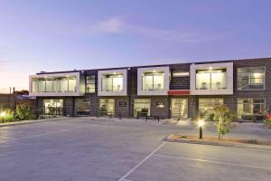 a building with a parking lot in front of it at Bridges on Argyle in Traralgon