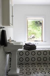 baño blanco con lavabo y ventana en Dingleigh of Sassafras, en Sassafras