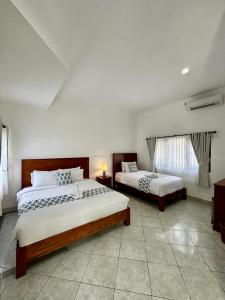 a bedroom with two beds and a window at Nusa Indah Bungalow in Nusa Lembongan