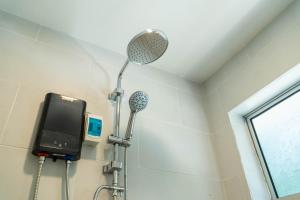 a shower in a bathroom with a shower head at Mulyo Hotel in Port Dickson