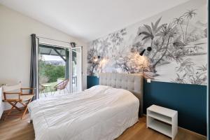 ユリューニュにあるVilla Ongizatea Maison d'Architecte à 10 minutes de St Jean de Luzのベッドルーム1室(ベッド1台付)、壁画が備わります。