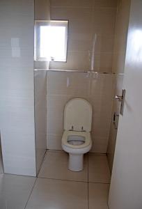 een kleine badkamer met een toilet en een raam bij Unit 57 Oceanic Hotel in Durban