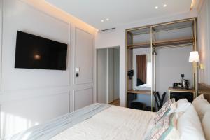 a bedroom with a bed and a tv on the wall at Aggelos Hotel in Alexandroupoli