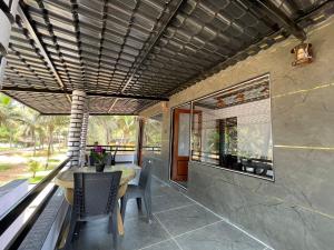 an outdoor dining area with a table and chairs at Rock n Ocean2 , Beach stay in Udupi