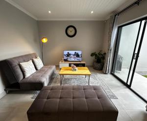 a living room with a couch and a table at Affordable Luxury Apartment in Gqeberha