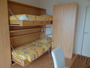 1 dormitorio con 2 literas y 1 silla en Seawind 503 with frontal sea view, en Nieuwpoort