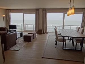 Sala de estar con mesa de comedor y vistas al océano en Seawind 503 with frontal sea view, en Nieuwpoort
