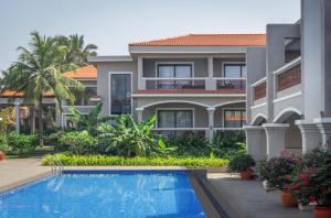 an apartment building with a swimming pool in front of it at Chalston Beach Resort in Calangute