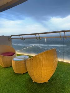 three chairs and a table on a balcony with a view at Spira supernova in New Delhi