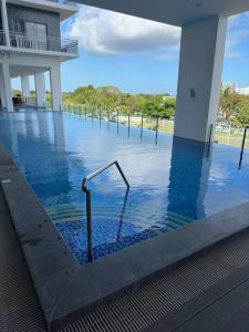a swimming pool with a hand rail in the water at Light 2Bedroom Loft @WVTowers#28 in Iloilo City