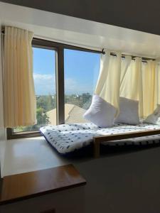 a bed in a room with a large window at Light 2Bedroom Loft @WVTowers#28 in Iloilo City