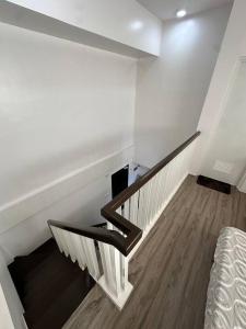 a staircase in a room with white walls and a bed at Light 2Bedroom Loft @WVTowers#28 in Iloilo City